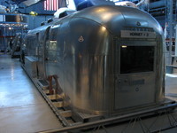 The Mobile Quarantine Facility that waited on board the USS Hornet at the conclusion of the first Moon landing, Apollo 11. The Hornet + 3 refers to the fact that they were welcoming three astronauts.